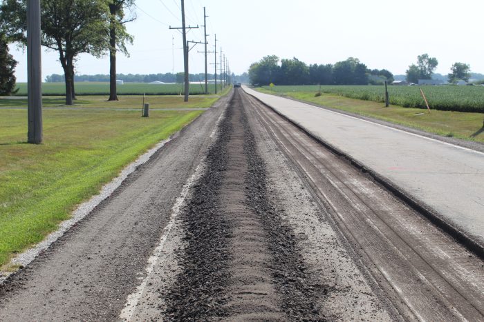 The road with the wearing course milled off and shoulder prepared, ready for CIR train to follow 